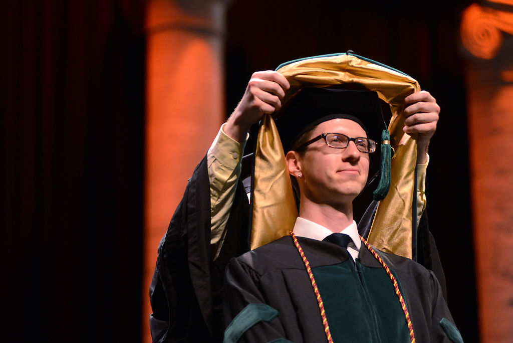 Britt Hultgren receives his hood during commencement